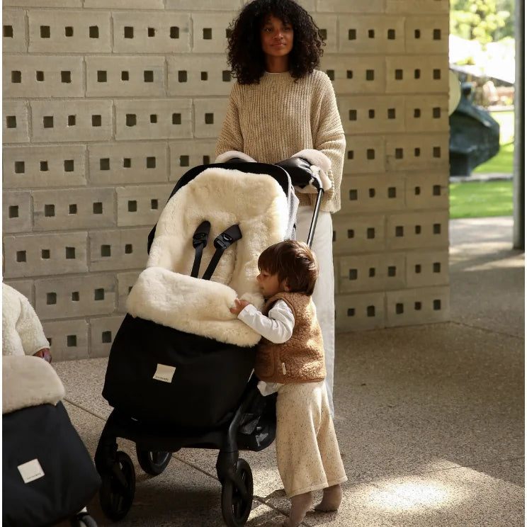 Schwarzer Kinderwagen-Fußsack Puffmuff mit weißem Plüschfutter und festem Geschirr