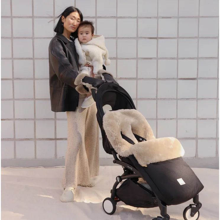 Schwarzer Kinderwagen mit cremefarbenem Kunstfell-Futter, modernem Design, Puffmuff Fusssack und fester Harness in Toast