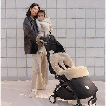 Schwarzer Kinderwagen mit cremefarbenem Kunstfell-Futter, modernem Design, Puffmuff Fusssack und fester Harness in Toast