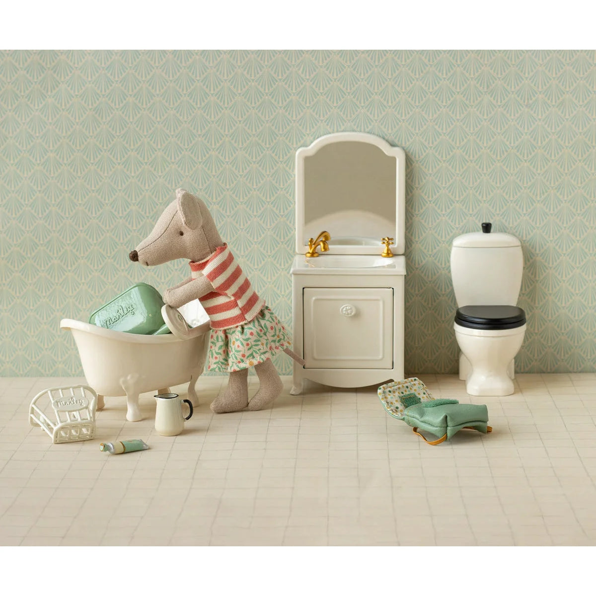 Ein plüsch maus-figürchen mit kleidungsset in rot-weiß gestreift und blumenrock neben mini badewanne geschenke für neugeborene