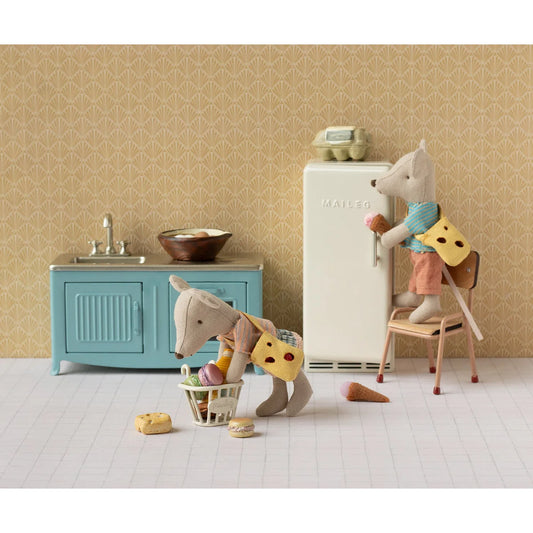 Weißer kühlschrank mit vintage design und mailer logo zum aufbewahren im kleidungsset mit tasche für kleine schwestermaus