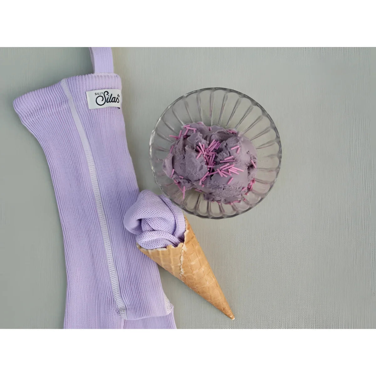 Kurze lavender strumpfhose mit träger aus nachhaltiger wolle und lavender knit eisbecherhülle mit billy silas etikett und zipper detail