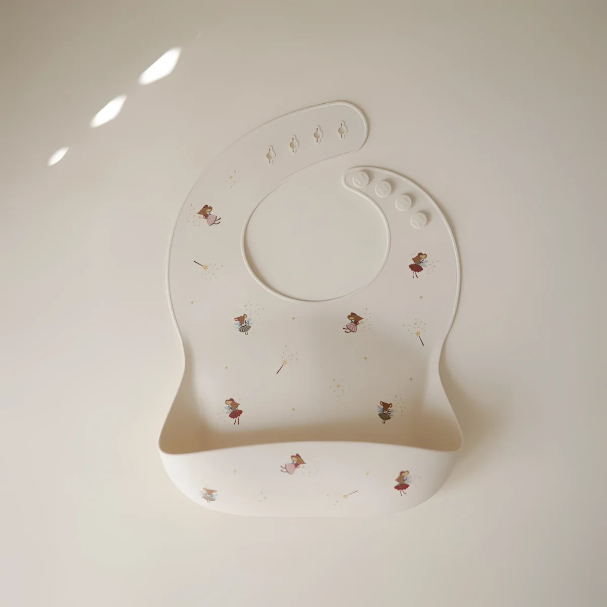 Weißes silikonlätzchen mit feinem muster winziger feeillustrationen nachhaltige babykleidung schweiz geschenke für neugeborene