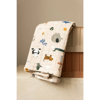 Faltbare hellbeige Baumwollmusselin-Decke mit bunten Tierillustrationen für Babys