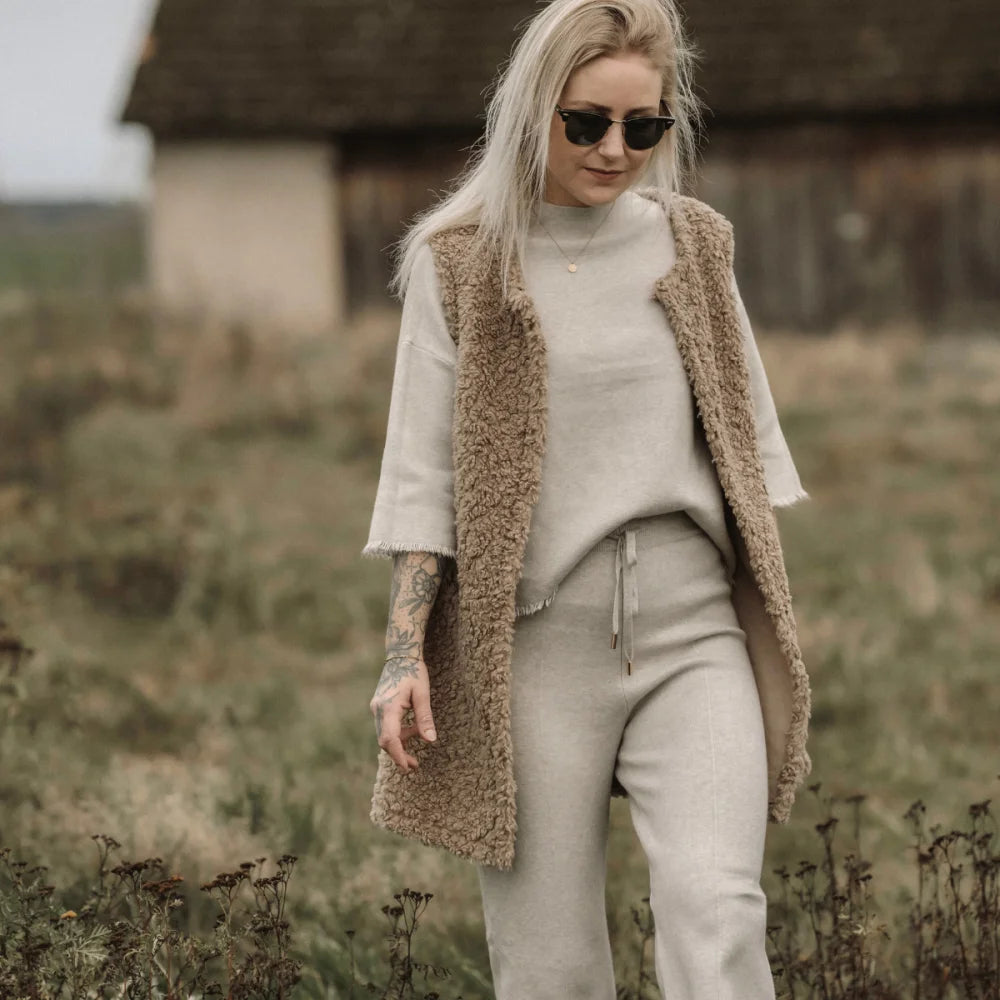 Stilvolles monochromes Outfit mit cremefarbener Strickjacke und beigem Teddy-Weste