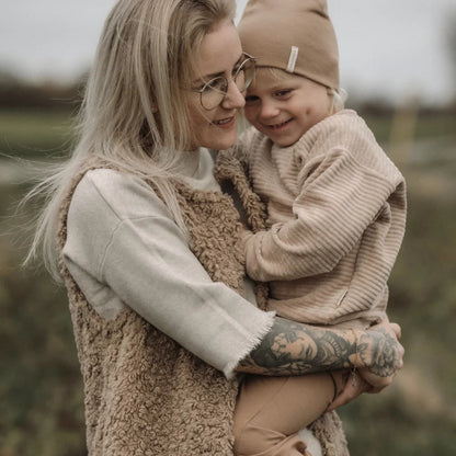 Ein zärtlicher Moment zwischen Eltern und Kind in gemütlichen Winterkleidung