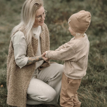 Ein zärtlicher Moment zwischen Elternteil und Kind in neutralen Winterbekleidungen