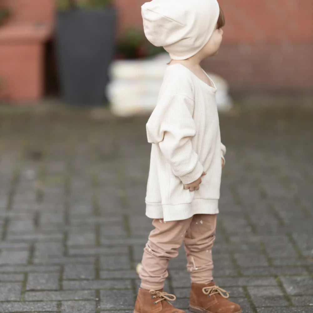 Cremefarbene Hoodie mit Känguru-Tasche, Beige Hose und braune Stiefel