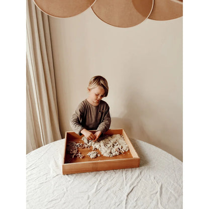 Junges Kind spielt mit Magic Sand 1kg oder 3kg in einem sensorischen Behälter