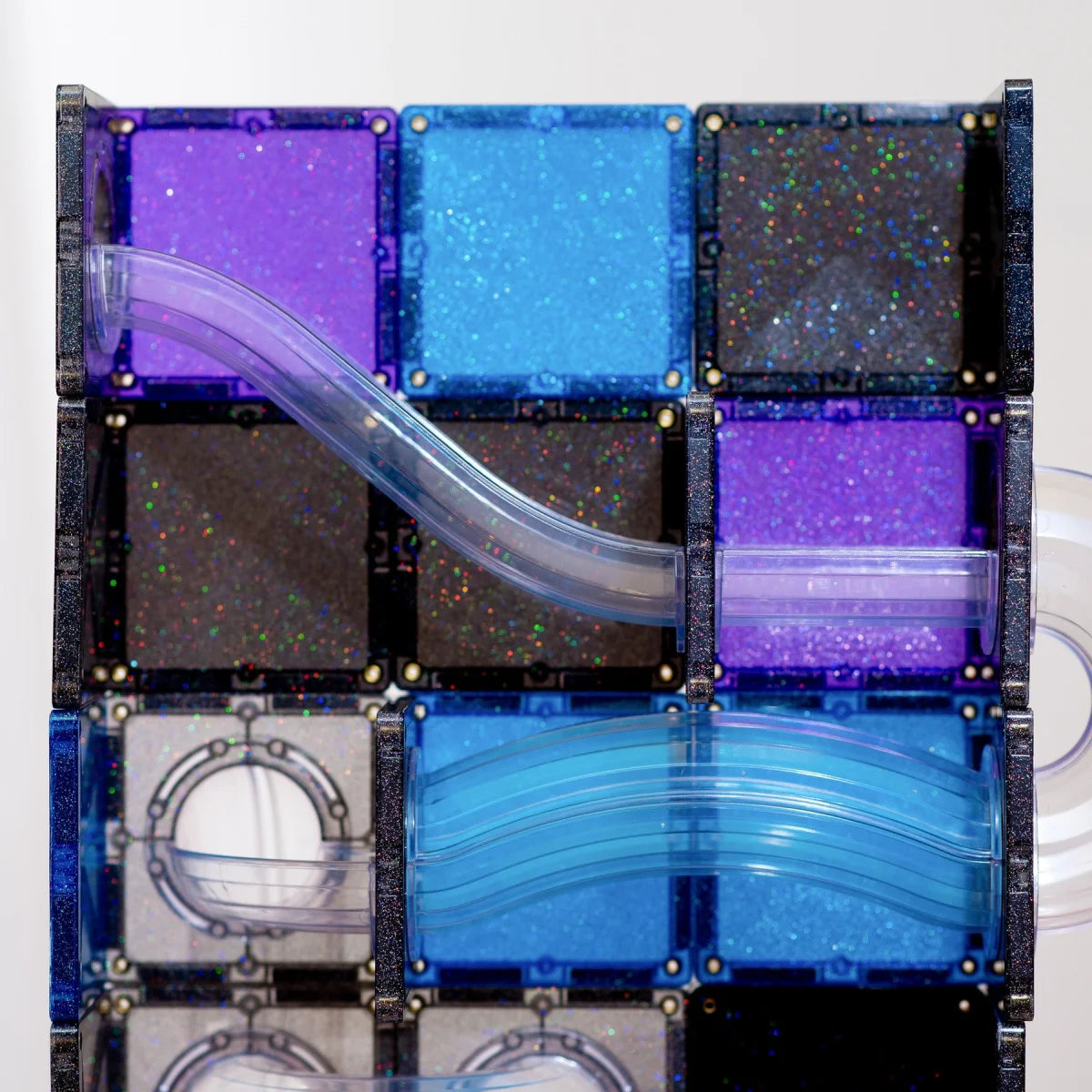 Detailaufnahme der Connetix Glitzer-Magnetbausteine in Blau, Violett und Schwarz mit Rutsche