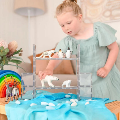 Holzspielzeugregal mit Eisbären und Pinguinen auf blauer Decke im Arctic-Szenario