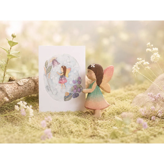 Holzfee maya fee mit grün-rosa verlaufskleid und rosa flügeln mit weißer blume als ökologische geschenke für neugeborene