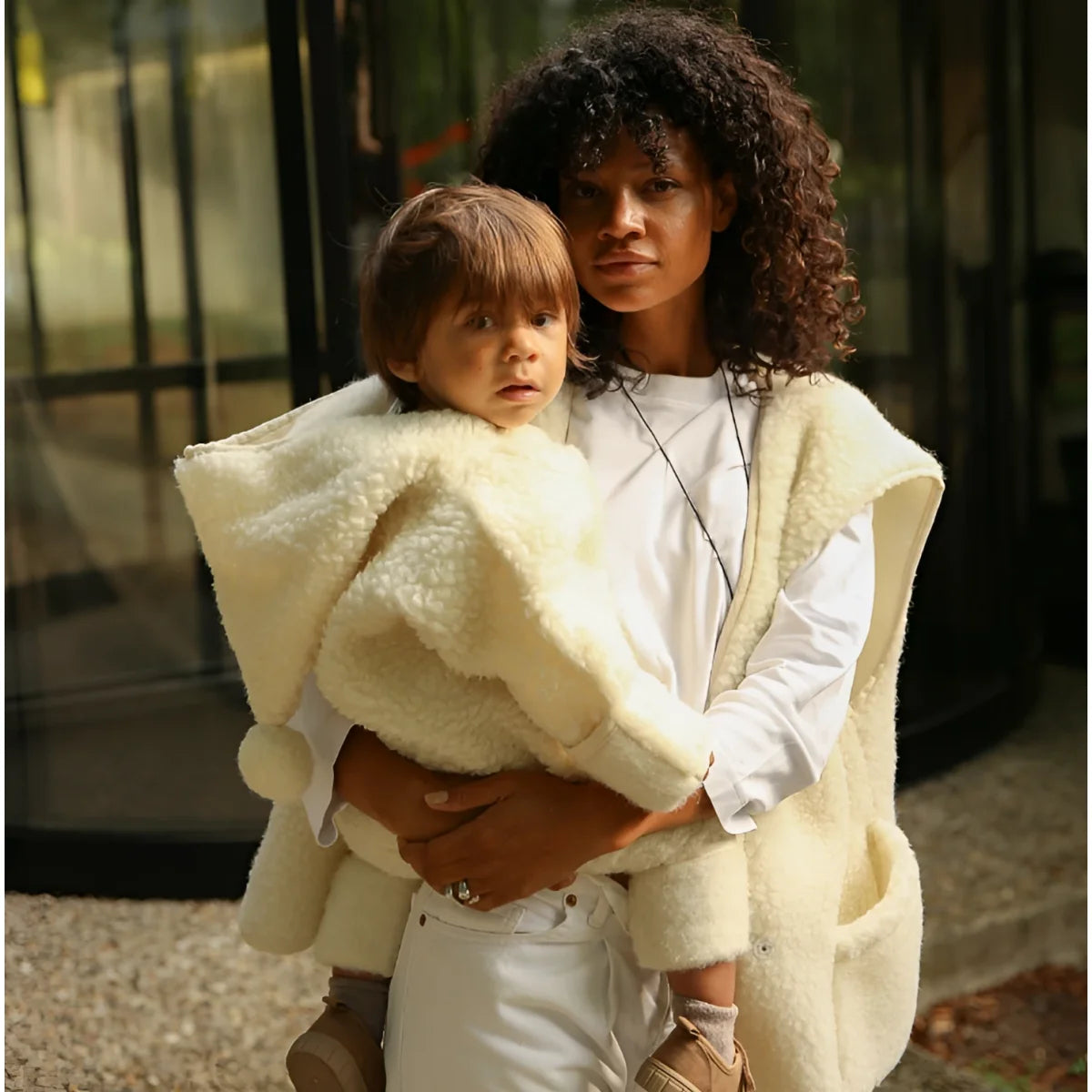 Creamfarbige merino mama gilet mit weicher, flauschiger schurwollstruktur und offenem frontdesign für ökologische babyprodukte