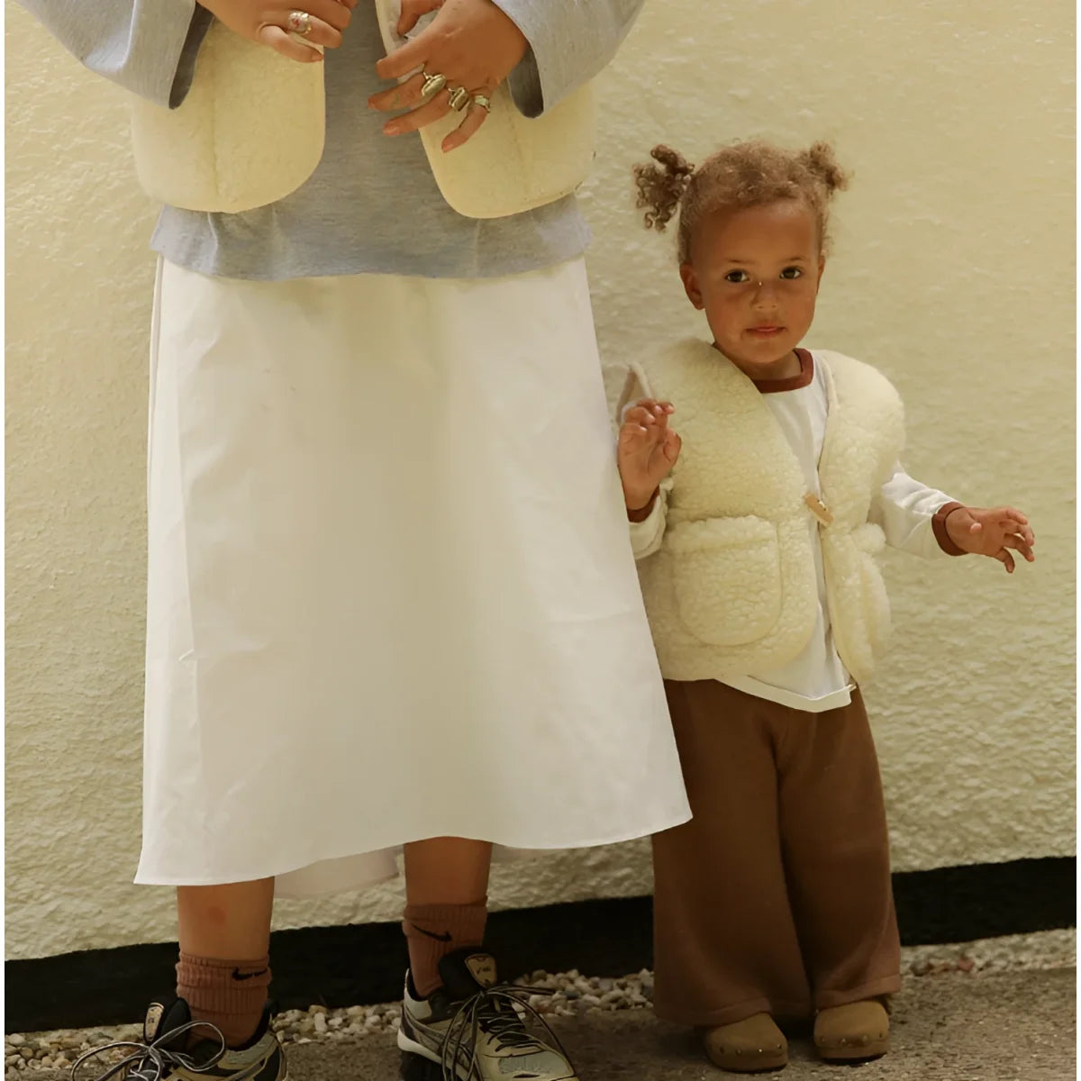 Creamfarbige, kuschelige merino mama gilet aus schaffell mit frontverschluss und zwei seitentaschen für nachhaltige babykleidung schweiz