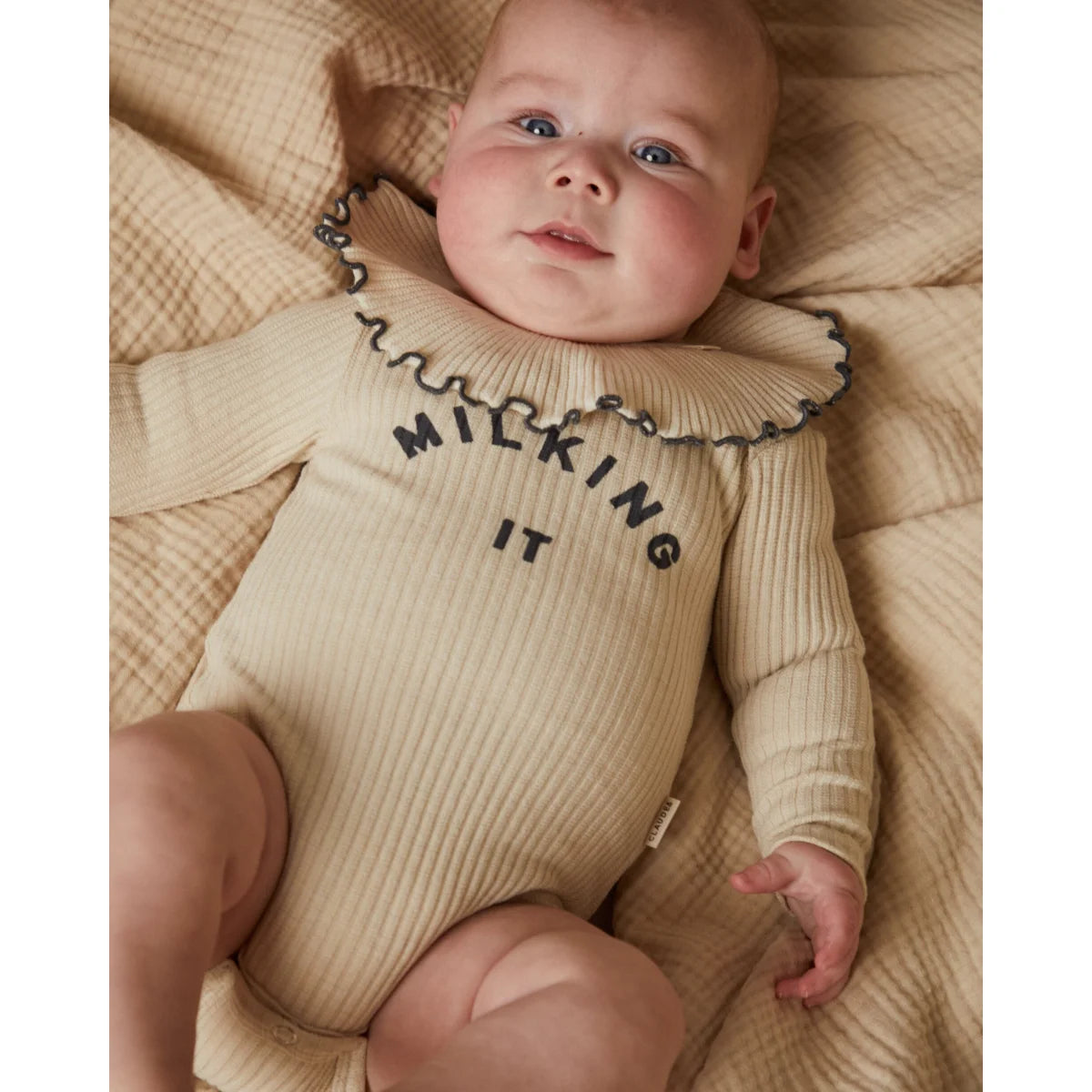 Beige geripptes babybodysuit mit rüschensaum und milking it schwarz bedruckt aus weichem material