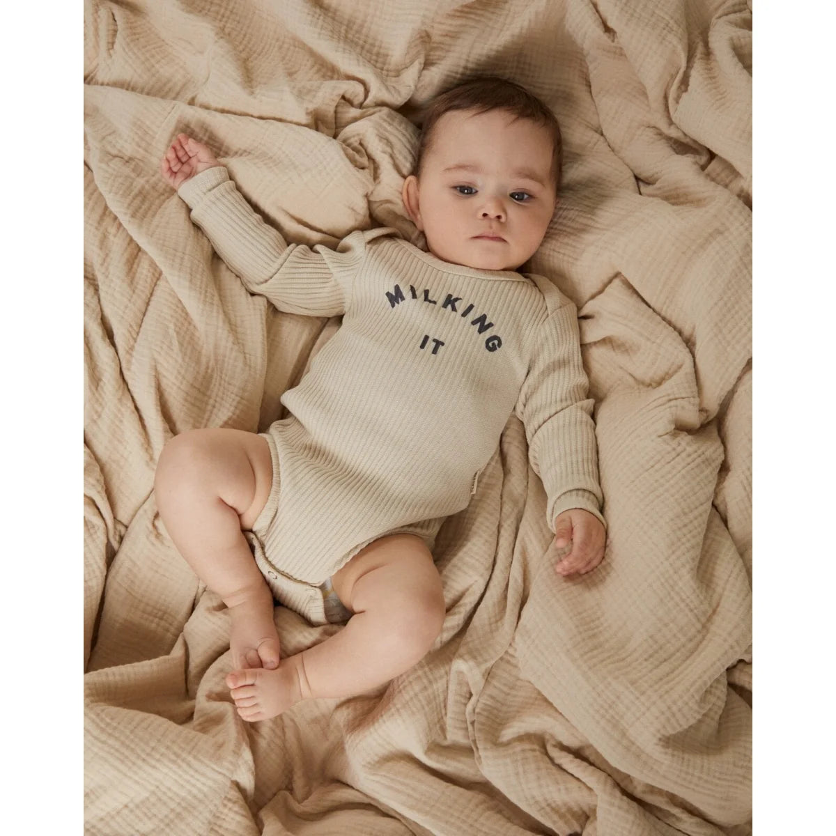 Beiges geripptes baby-langarmbody aus baumwolle mit milking it aufdruck in dunkelgrau von milking it bodysuit oat