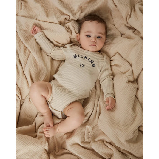 Beiges geripptes baby-langarmbody aus baumwolle mit milking it aufdruck in dunkelgrau von milking it bodysuit oat