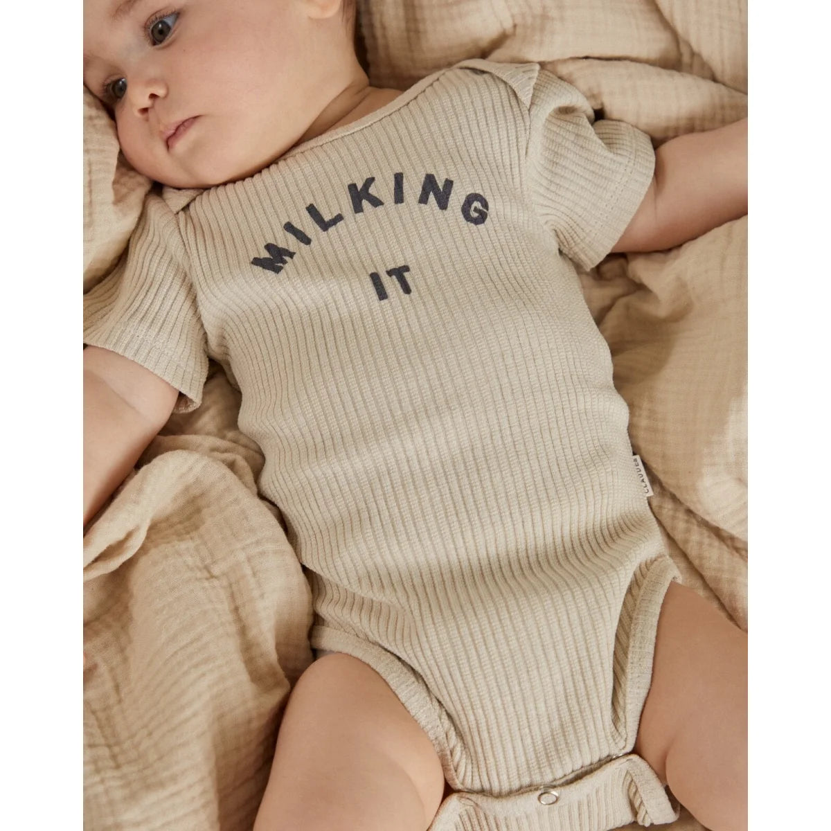 Beige geripptes kurzarm-babystrampler milking it in dunkelgrau aus weicher baumwolle in oat farbe