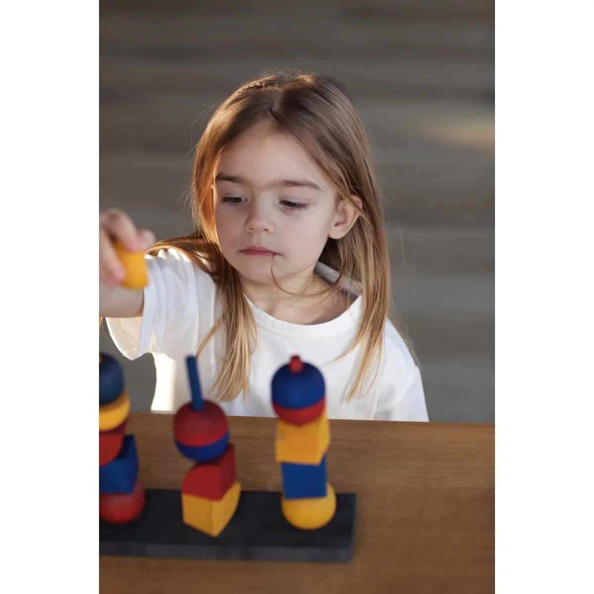 Moderner stacking toy y mit bunten roten, blauen und gelben holzbausteinen als ökologisches baby- & kinderprodukt