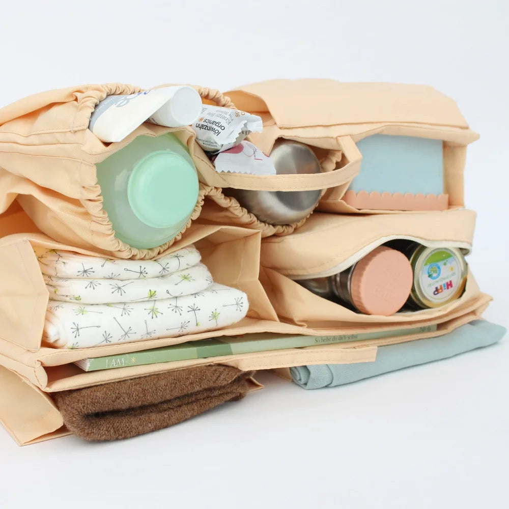 Stoffwindeltasche mit Babypflegeprodukten im Mom Bag Organizer in Beige