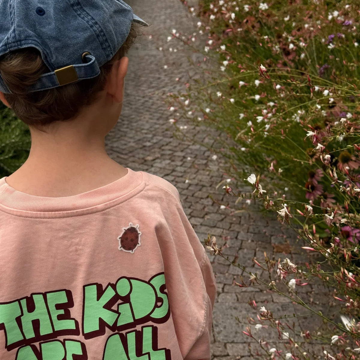 Marienkäfer-Sticker auf dem Rücken eines rosa Shirts beim Spaziergang