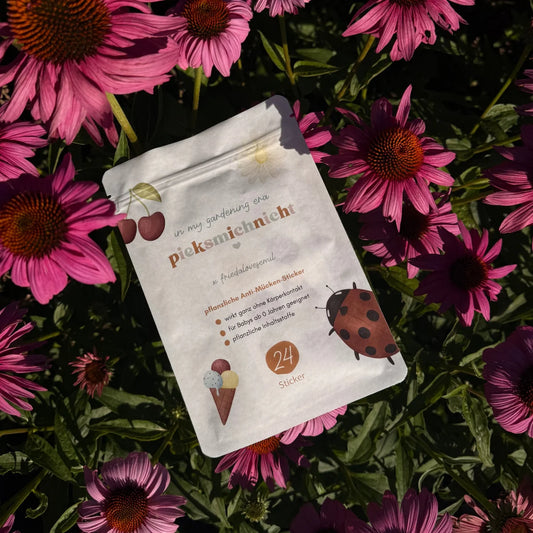 Mückenschutz friedalovesemil Limited Edition: Verpackung mit 24 Anti-Mücken-Stickern zwischen pinken Sonnenhut-Blüten