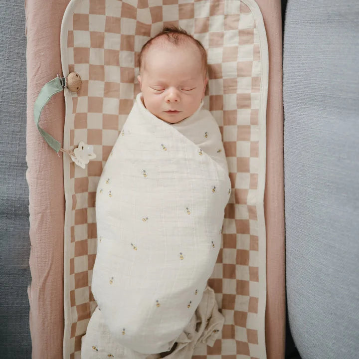 Swaddled Baby auf kariertem Wickelunterlage für Mulltuch Bees Produkt