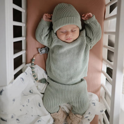 Schlafendes Baby in mintgrünem Strickoutfit und passender Mütze von Mulltuch Wale