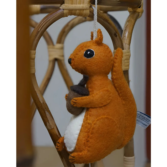 Oranges Filz-Eichhörnchen mit Eichel, Detailansicht