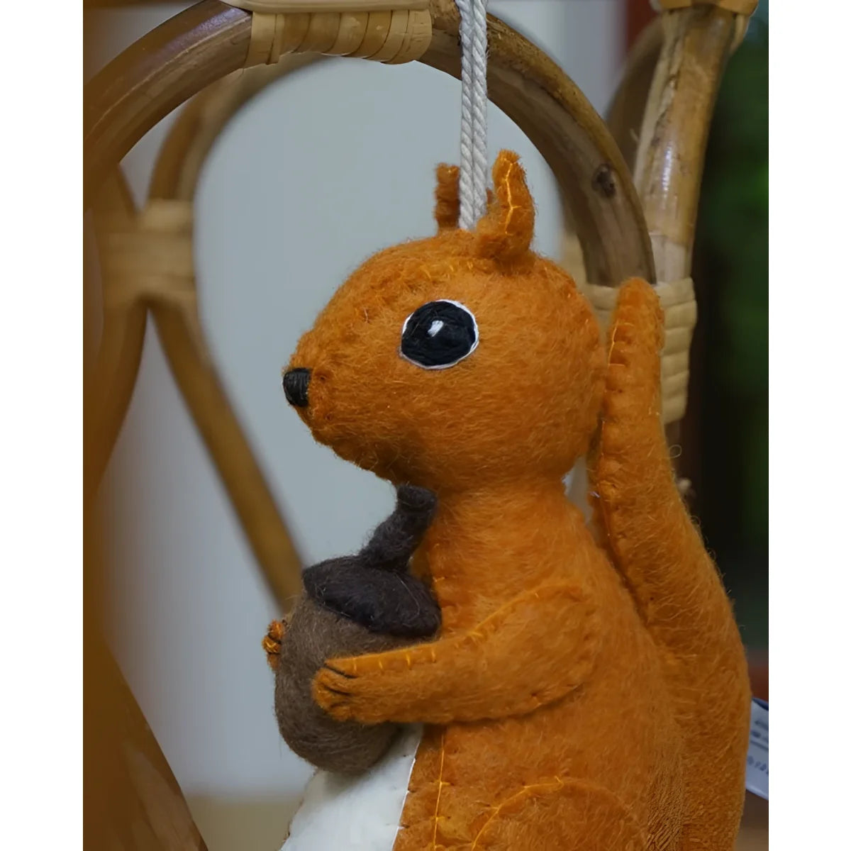 Musikspieluhr Eichhörnchen Orange am Kinderbett aufgehängt