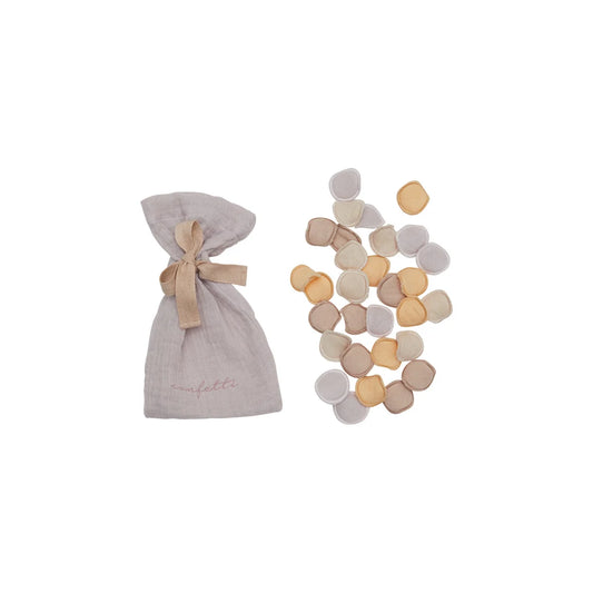 Ein beiges musselin konfetti pouch mit passenden band und pastellfarbenen rosenblatt-konfetti ideal für nachhaltige babykleidung schweiz geschenke für neugeborene