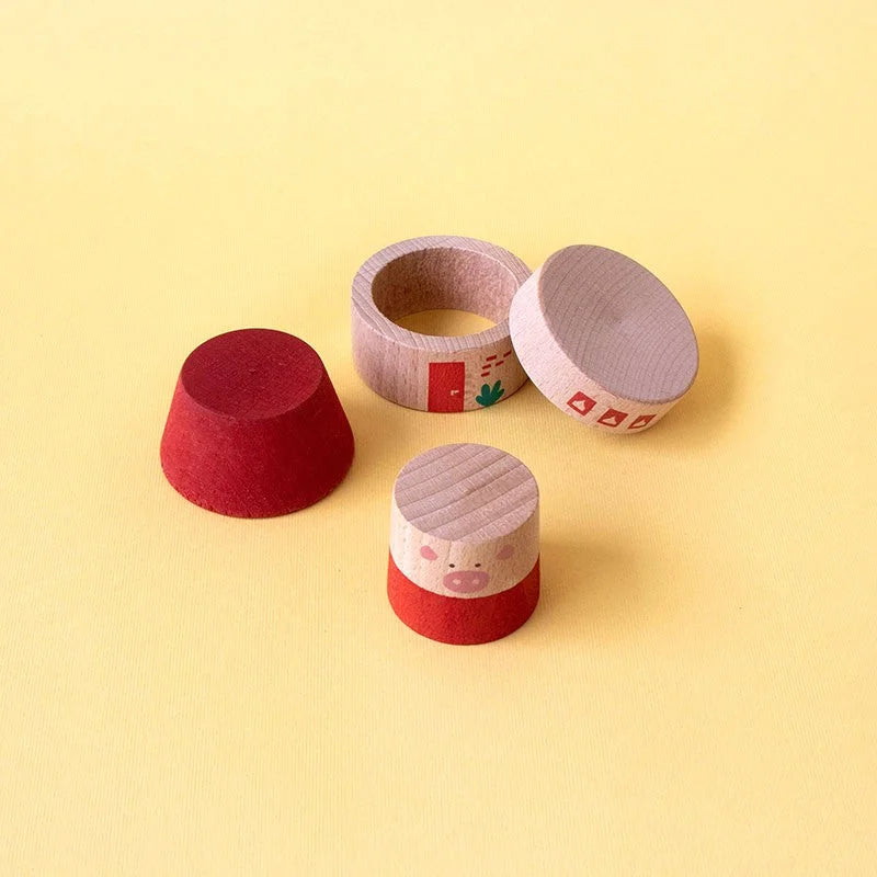 Holzschweinspielzeug mit rotem Sockel und hellem Holz, rosa Schnauze und Augen aus My Three Little Pigs