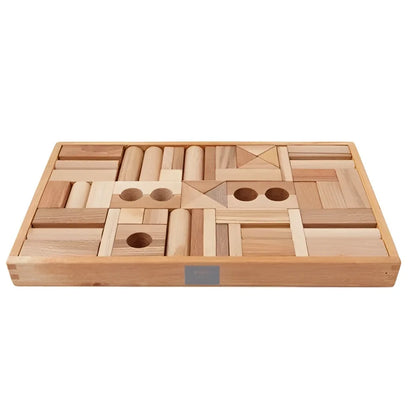 Natürliche holzbausteine in verschiedenen formen und größen in einem passenden holztablett für ökologische baby- & kinderprodukte