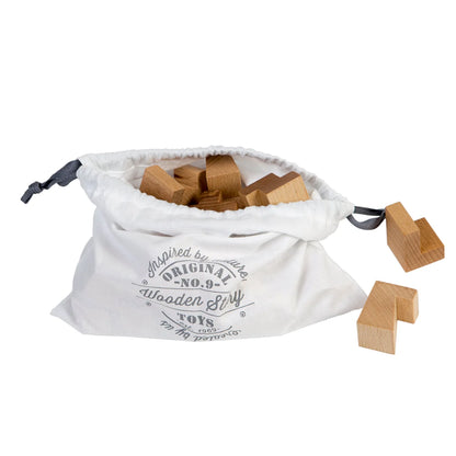 Weißer kordelzugbeutel mit naturfarbenen holzbausteinen und original no9 wooden toys logo für nachhaltige babykleidung schweiz