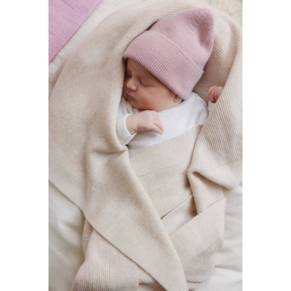 Baby mit rosa Newborn Beanie Fonzie aus Merinowolle