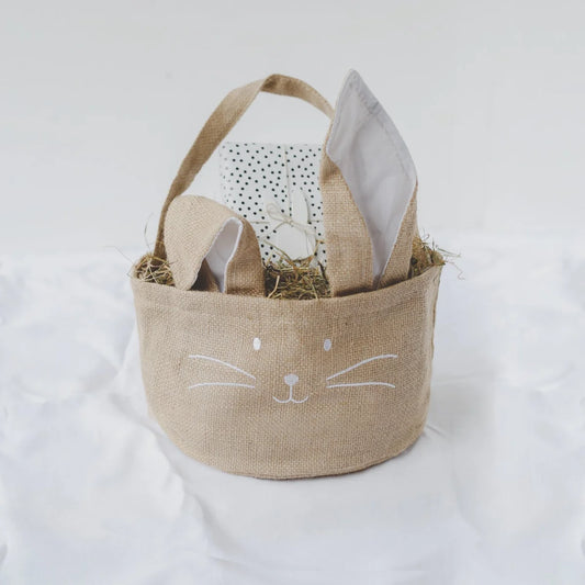 Osterkorb aus beige Jute mit weißem Hasengesicht, Heu und gepunktetem Geschenk