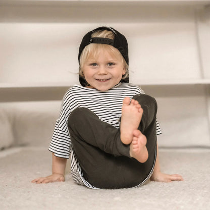 Lächelndes Kind in gestreitem Hemd und schwarzem Hut für Oversized Shirt Stripes