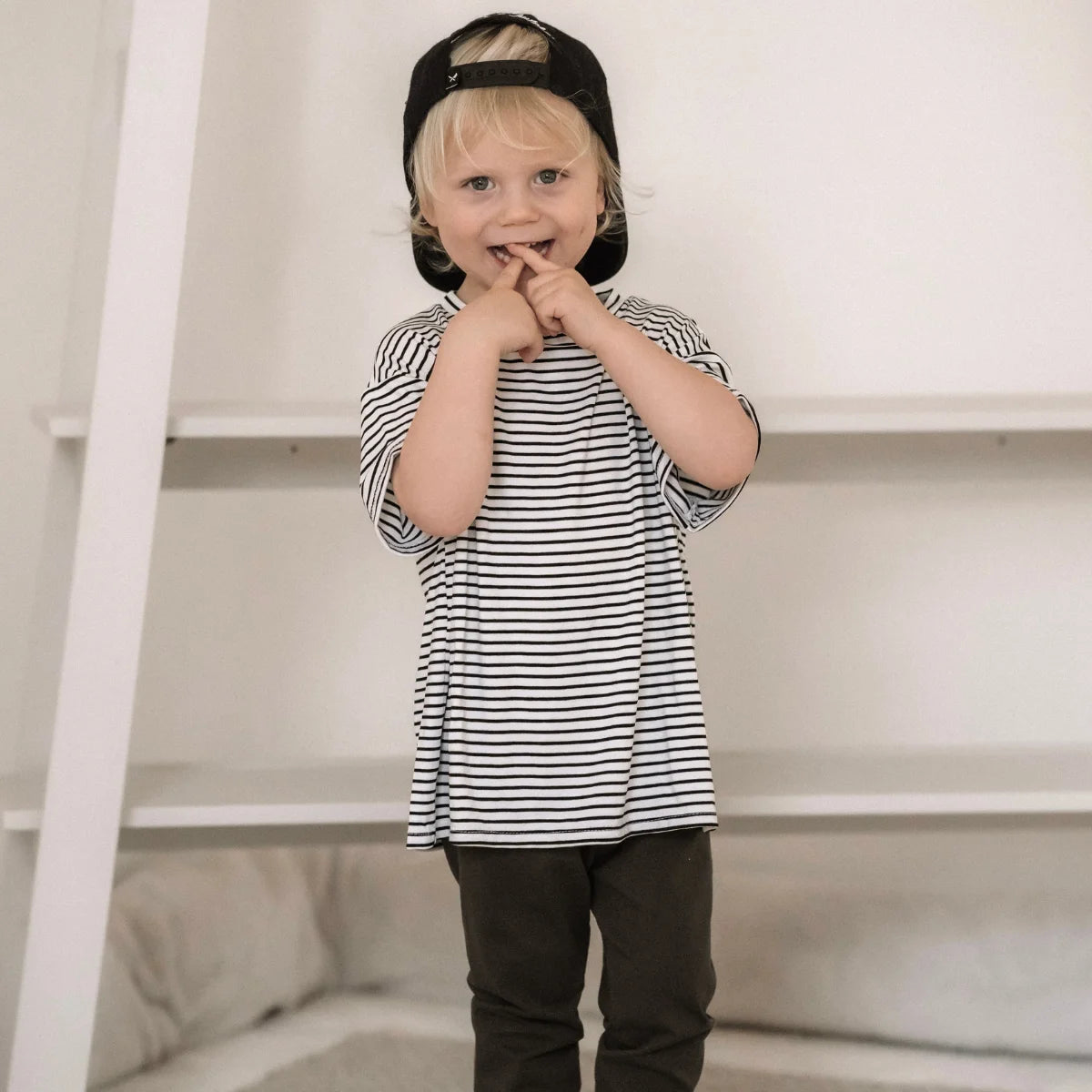 Kind eines Kindes in gestreiftem Hemd und Mütze für das Produkt Oversized Shirt Stripes