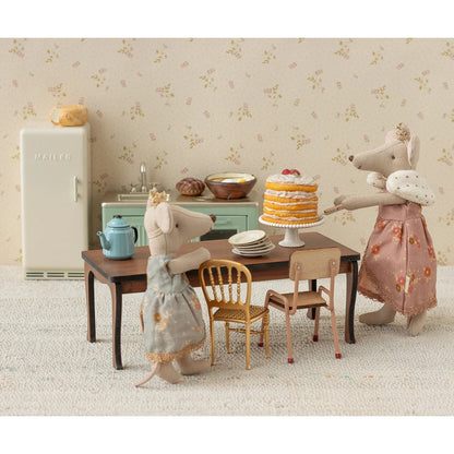 Partytorte mit tortenständer in off white mit mehrstöckigem gelben kuchen, weißer frosting und roten beeren, ideal für geschenke für neugeborene
