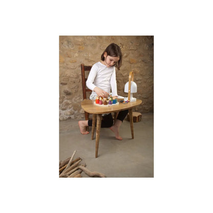 Holz ovaler Tisch mit bunten Flaschen und kleinem Stuhl