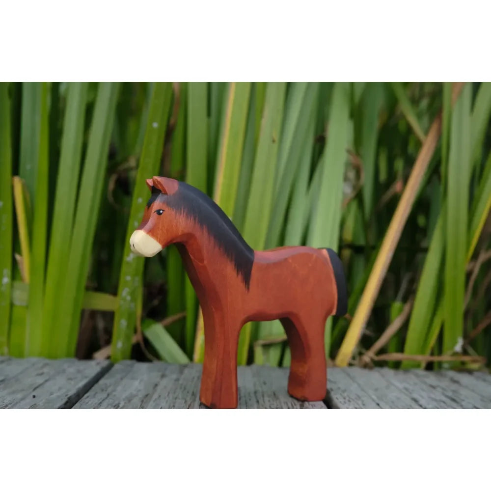 Holzpferd Spielzeug mit rötlich-braunem Körper, schwarzer Mähne und hellerer Schnauze