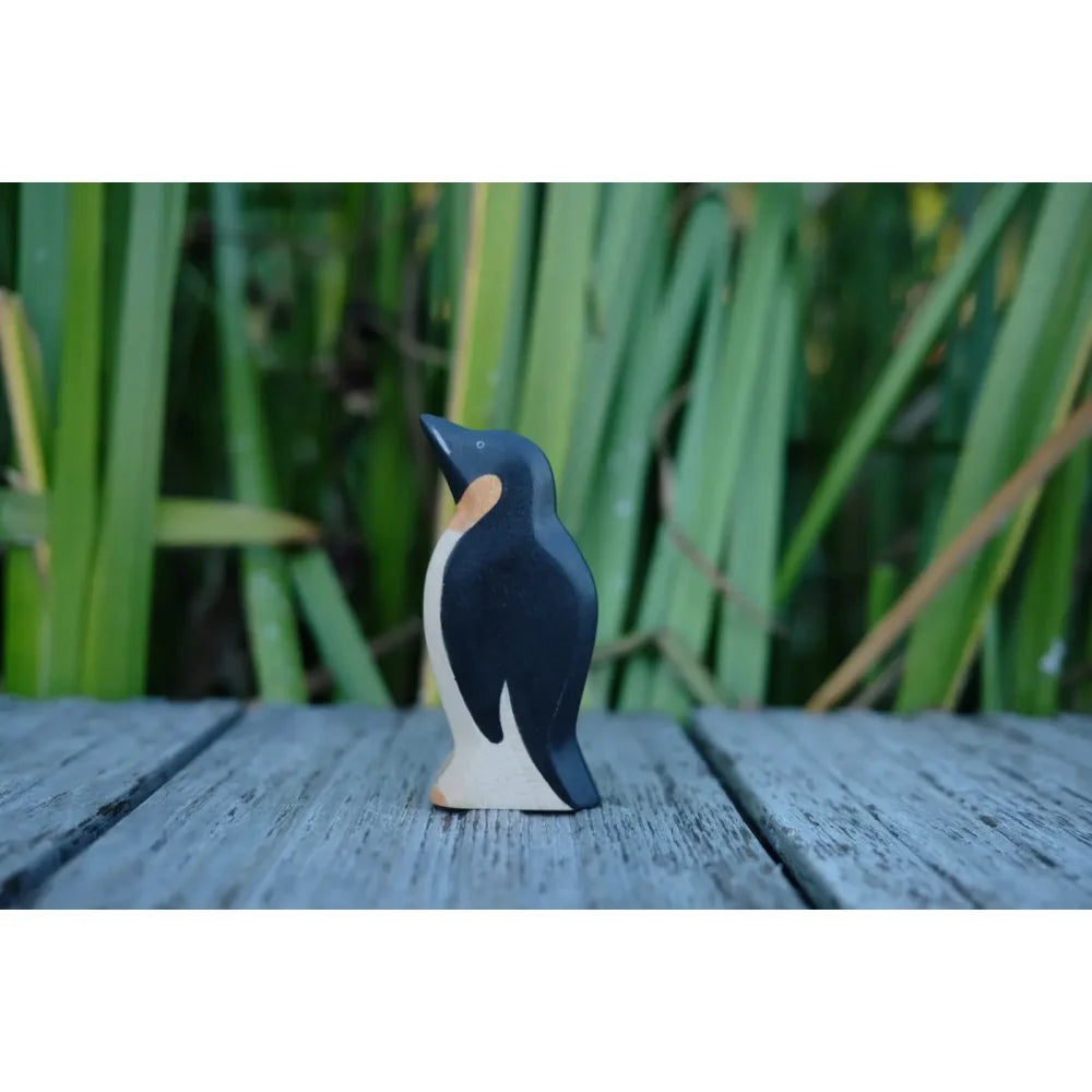 Schwarze weiße Holzpinguinfigur mit orangegelbem Akzent am Hals für das Produkt Pinguin