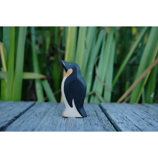 Schwarze weiße Holzpinguinfigur mit orangegelbem Akzent am Hals für das Produkt Pinguin