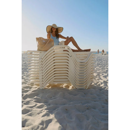 Eine frau mit strohhut sitzt neben dem buttergelben poplinn cotton striped mom bag, ideal für ökologische baby- und kinderprodukte