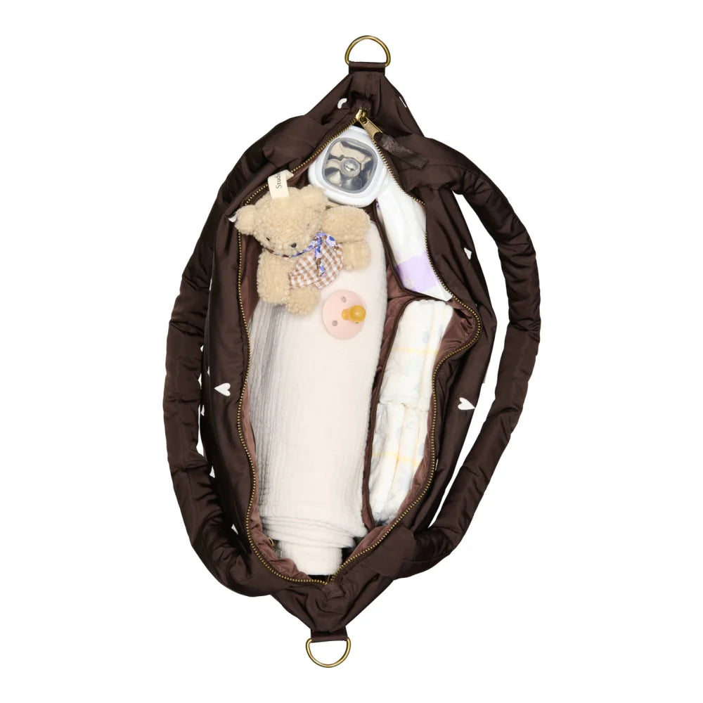 Offene braune Baby-Wickeltasche mit Inhalt aus dem Produkt Puffy Mom Diaper Bag Brown Hearts