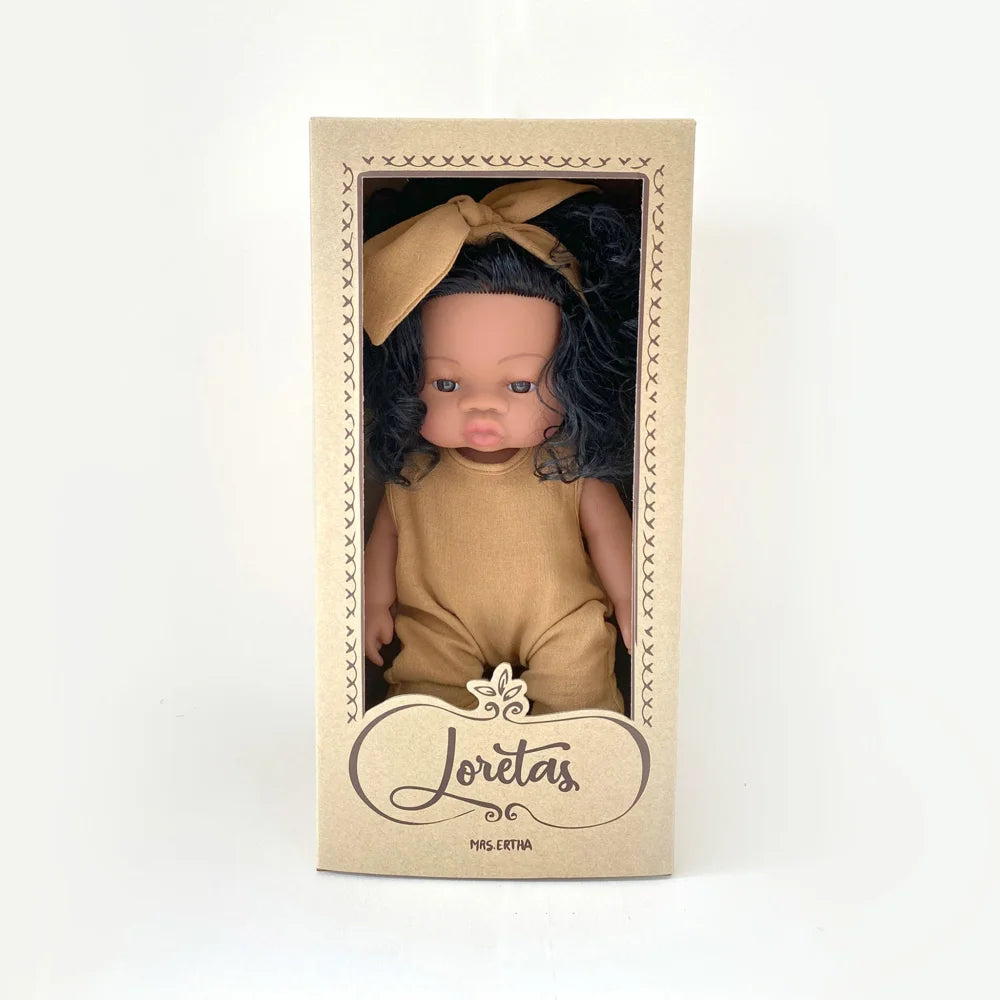 Baby doll in tan outfit inside Loritas display box for Puppe Loreta Fallen