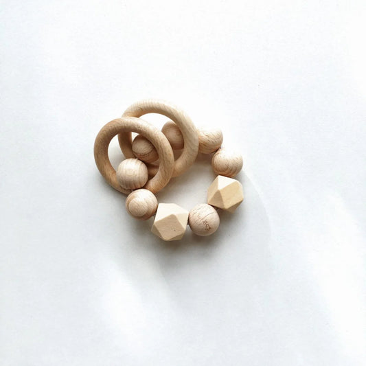 Natürlicher rassel geoperlen teether aus glattem holz mit abgerundeten kugeln und geometrischen facetten