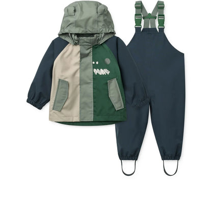 A kinder regenbekleidungsset manu play multi mix mit regenjacke und latzhose in olivgrün, marineblau und beige mit dino-motiv