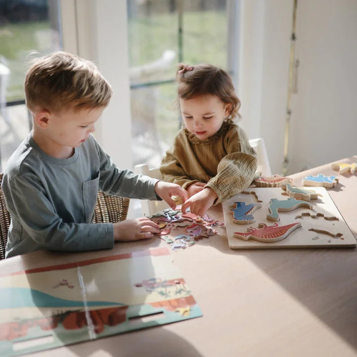 Zwei Kinder spielen mit einem Dinosaurier-Puzzle aus dem Wiederverwendbaren Sticker-Set Dino