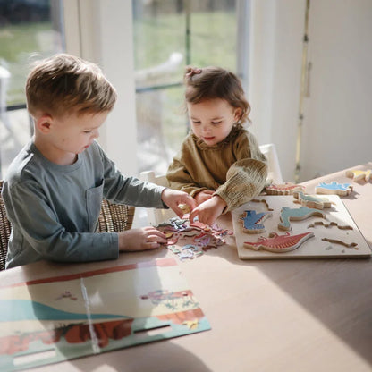 Zwei Kinder spielen mit einem Dinosaurier-Puzzle aus dem Wiederverwendbaren Sticker-Set Dino